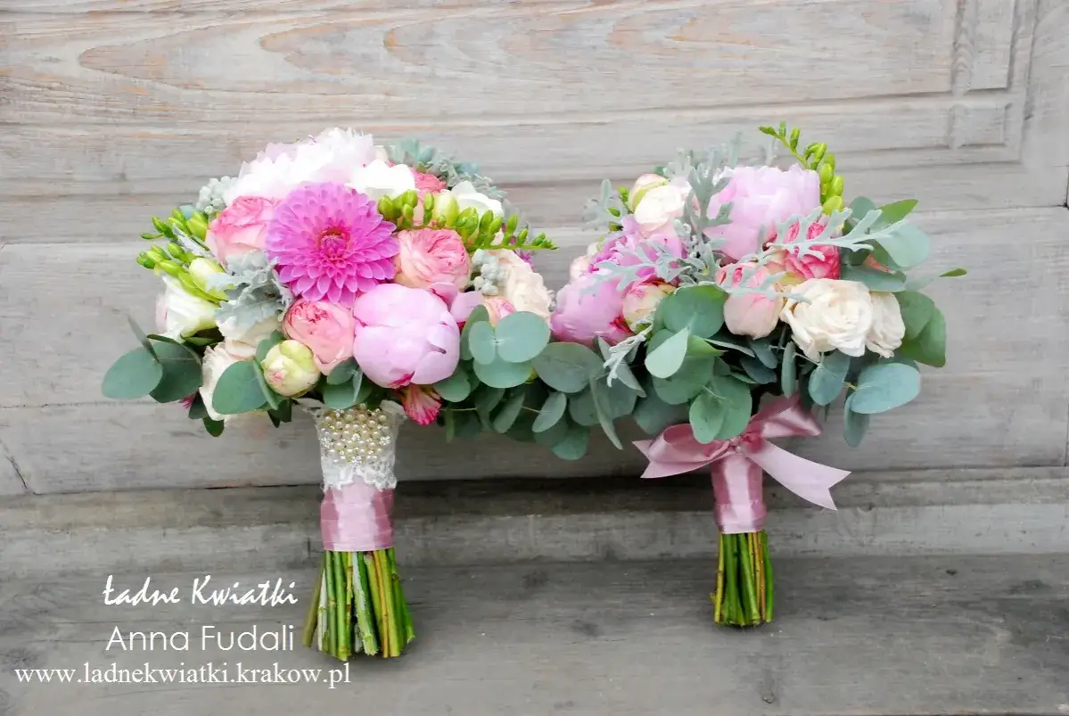 Dwa bukiety ślubne z r&oacute;żowymi piwoniami, r&oacute;żami i eukaliptusem, ozdobione perłami i satynowymi wstążkami. Idealne piwonie na ślub.