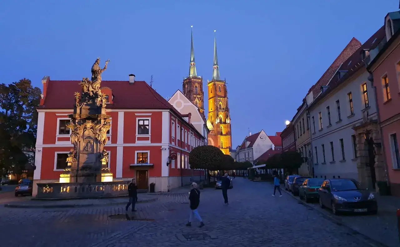 Wieczorny Rynek we Wrocławiu z katedrą w tle. To miejsce, z czego słynie Wrocław, przyciąga turyst&oacute;w.