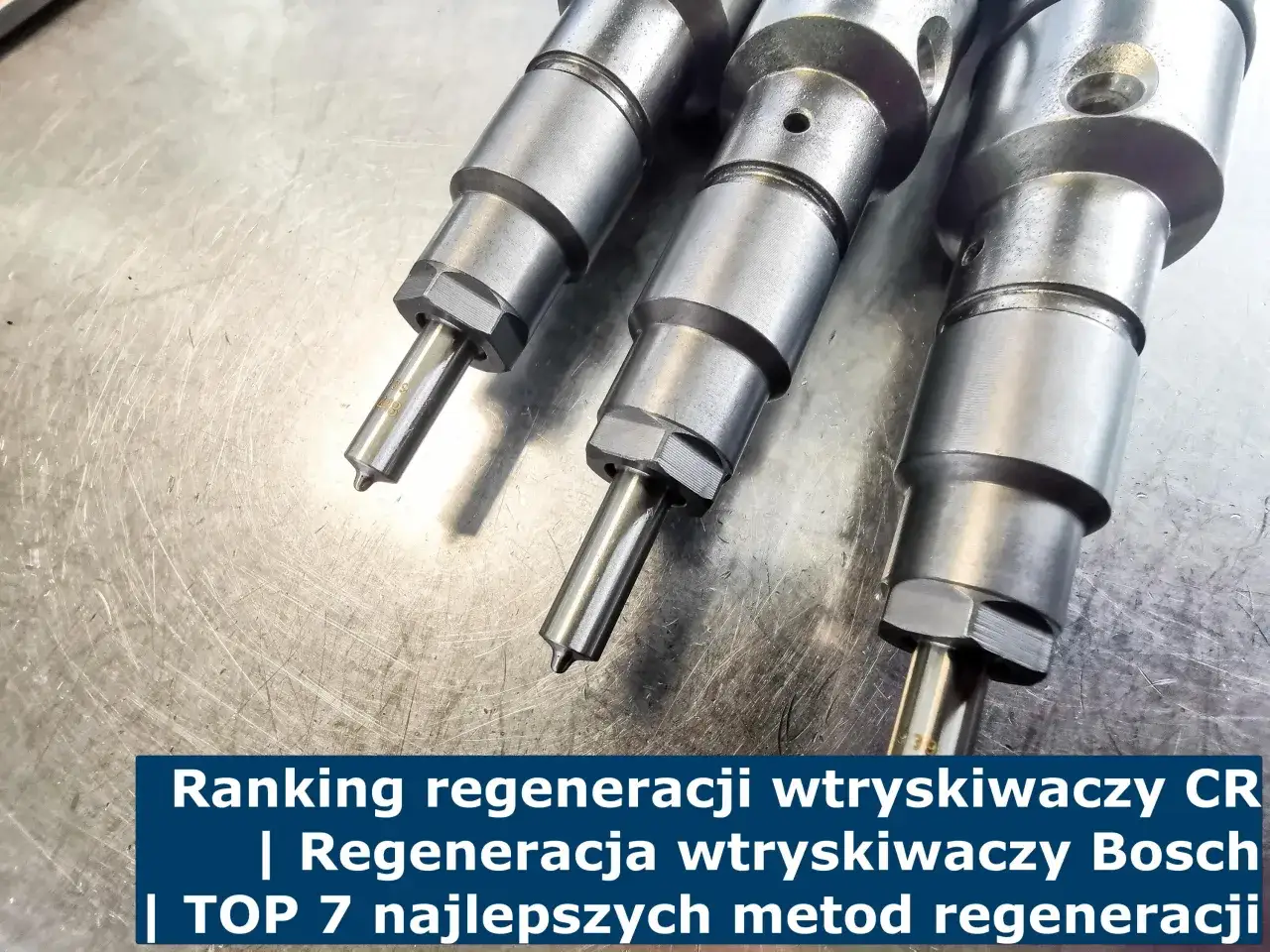 Trzy wtryskiwacze diesla na metalowym blacie. Dowiedz się, ile kosztuje regeneracja wtryskiwaczy CR i Bosch.