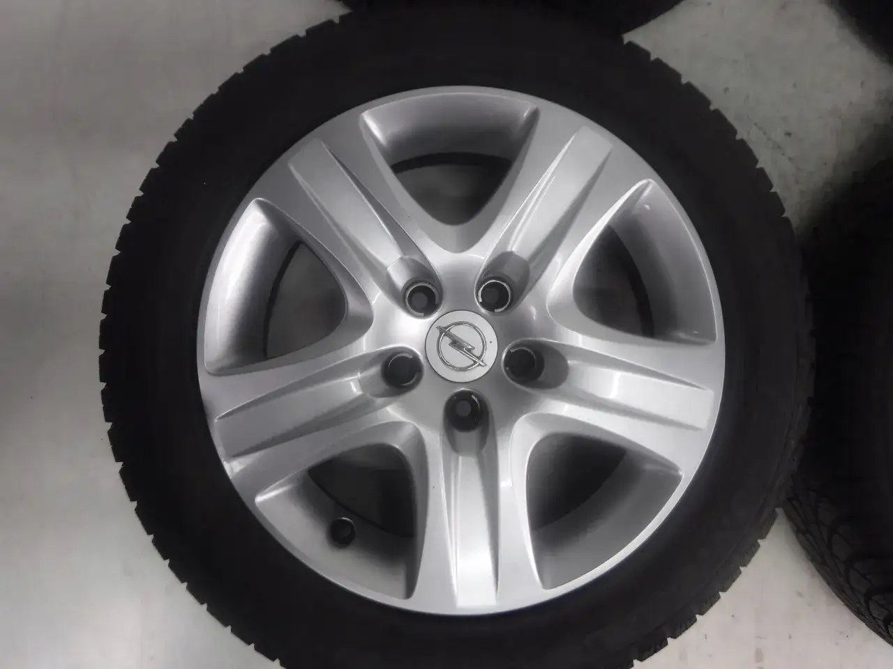 Srebrne felgi strukturalne Opel z oponą zimową.
