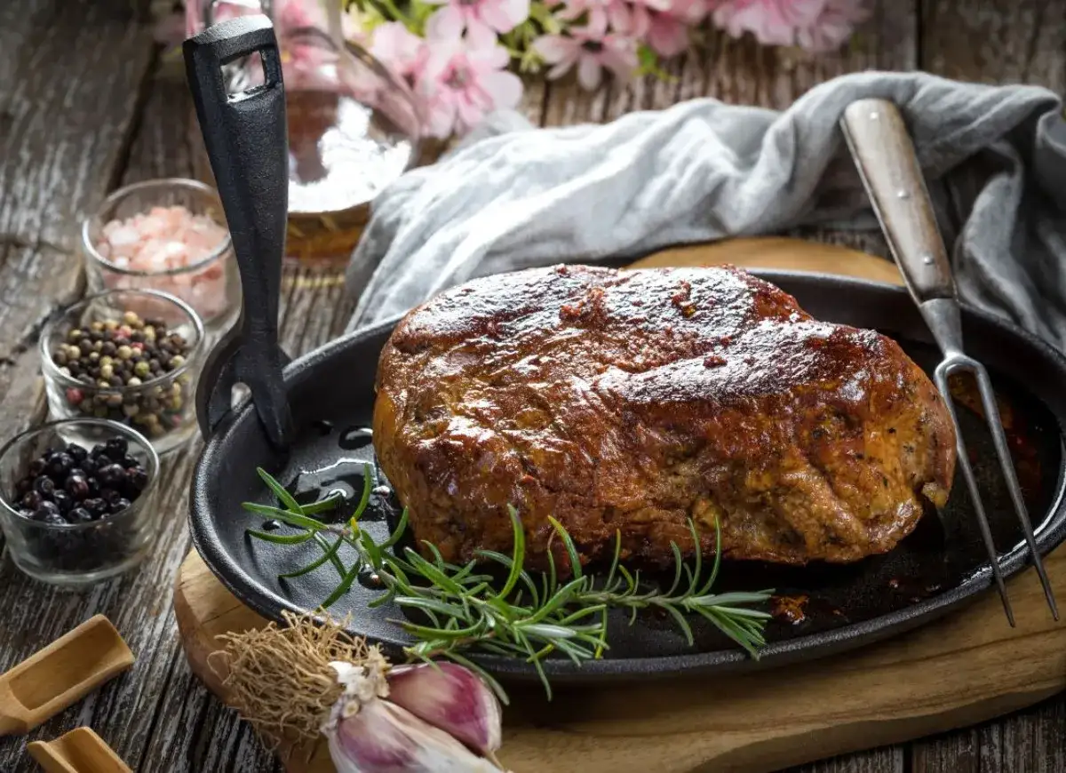 Soczysta kark&oacute;wka w naczyniu żeliwnym, gotowa na przyjęcie. Aromatyczne przyprawy i świeży rozmaryn podkreślają jej smak.