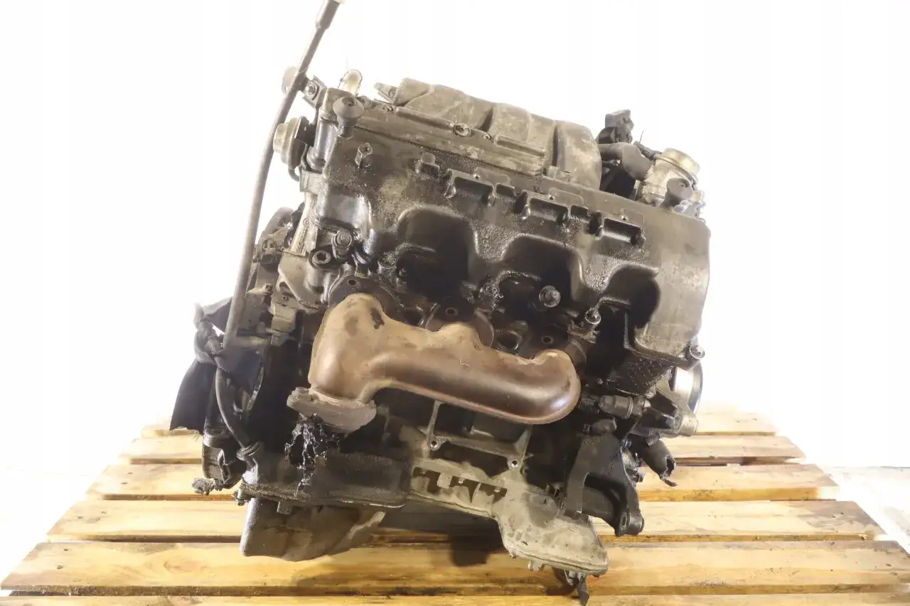 Silnik V6 z Mercedesa CLK W209, widoczny na drewnianej palecie, gotowy do montażu lub regeneracji.