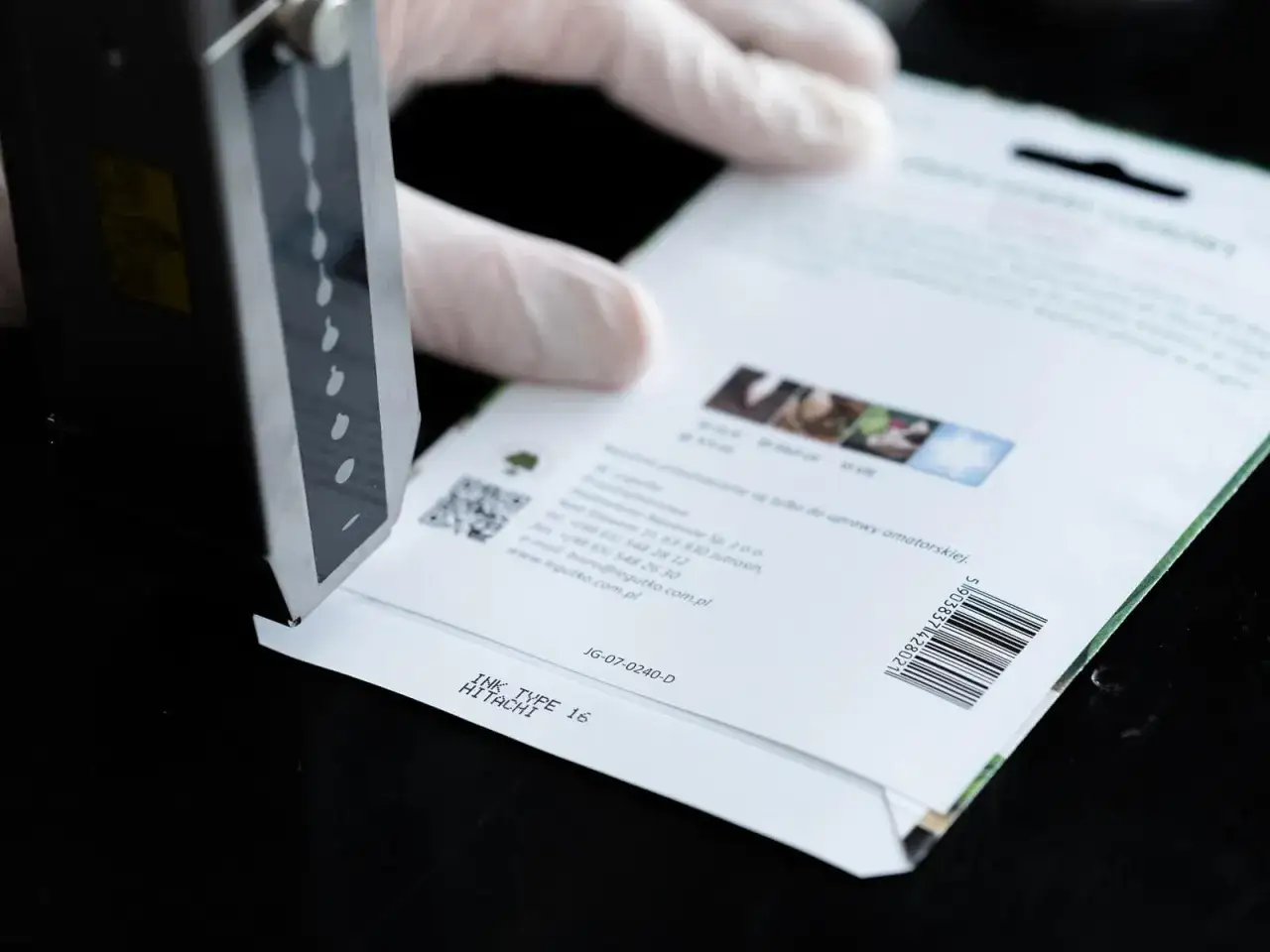 Rękawiczka z tworzywa sztucznego zakrywa opakowanie nasion, na którym drukowany jest numer partii produkcyjnej.