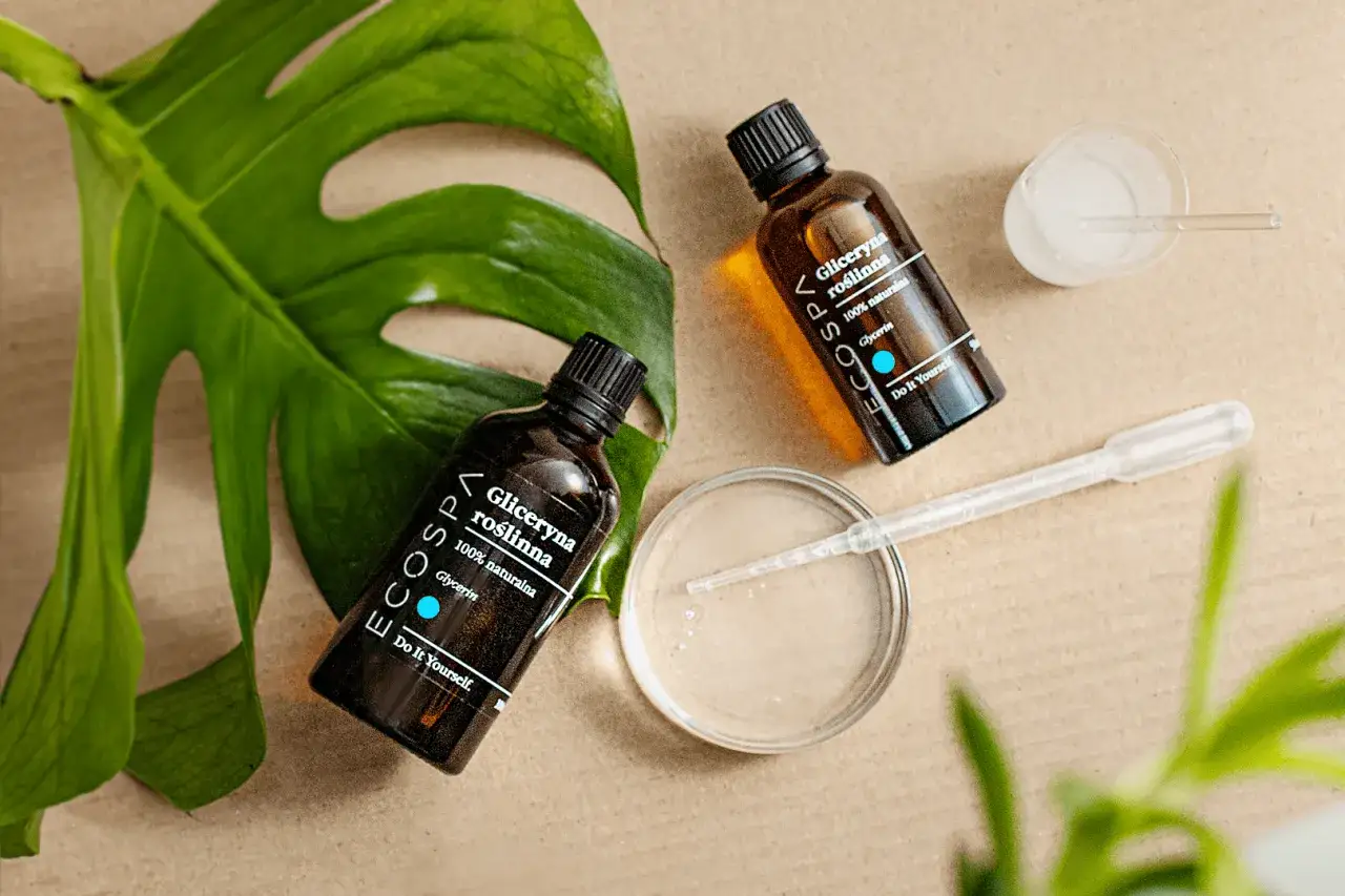 Naturalna gliceryna roślinna w buteleczkach, pipeta i liść monstery. Idealne składniki, by dowiedzieć się, jak zrobić glicerynę w domu.