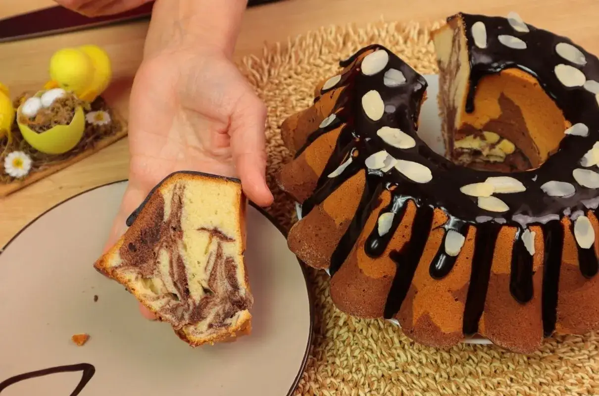 Wilgotna babka wielkanocna dwukolorowa, polana czekoladą i posypana płatkami migdał&oacute;w. Idealna na świąteczny st&oacute;ł.