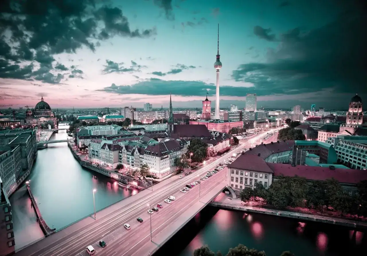 Widok na Berlin nocą, z rzeką, mostem i wieżą telewizyjną. Ciekawe ciekawostki o Berlinie czekają na odkrycie w tym mieście!
