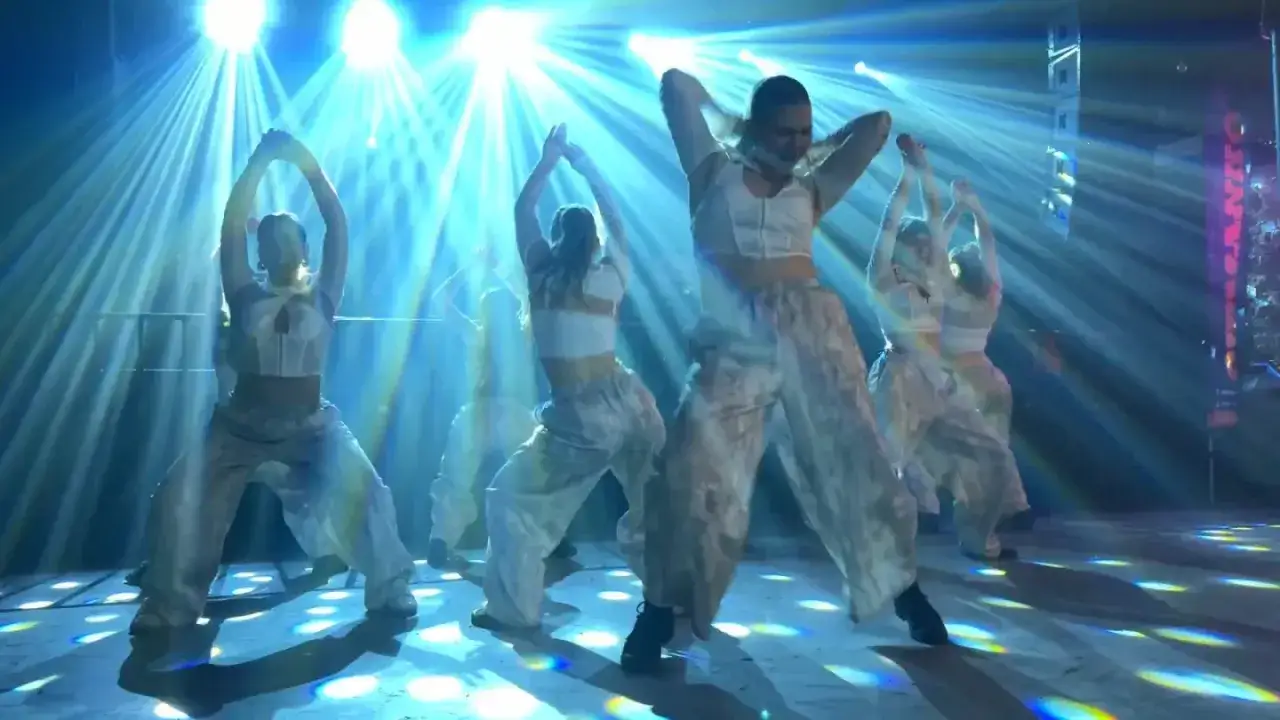 Tancerki w białych strojach wykonują dynamiczny taniec, przypominający twerkowanie co to za styl.