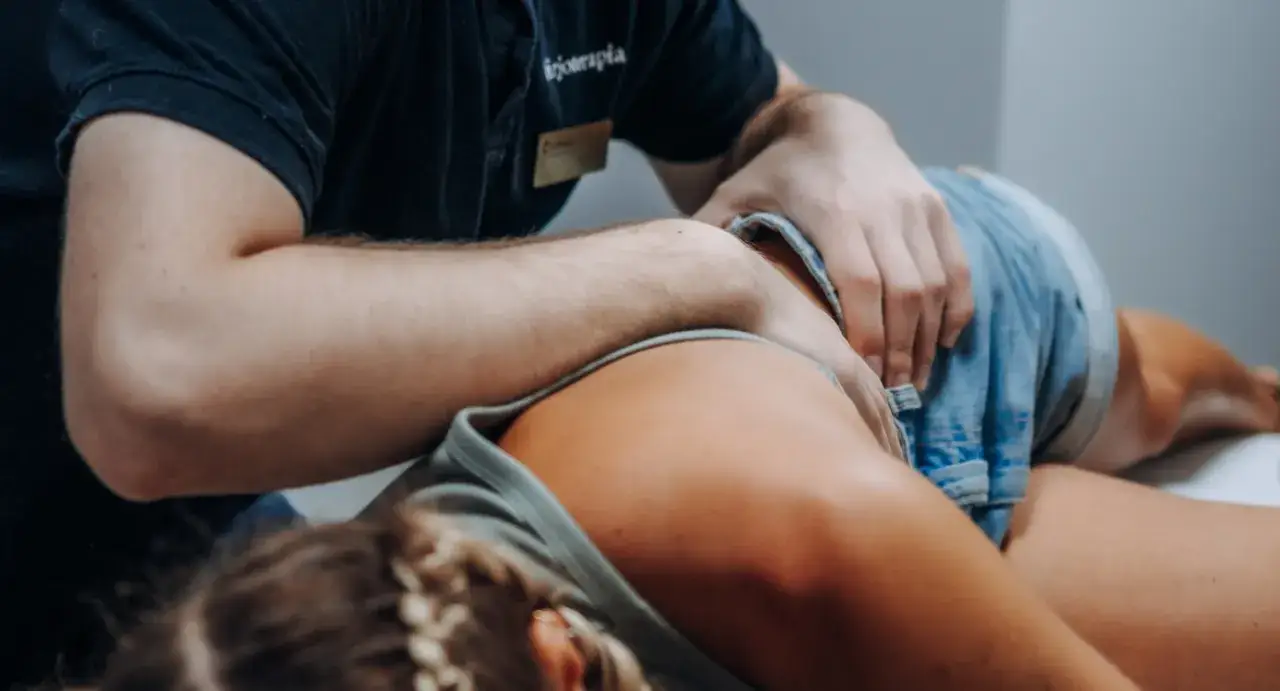 Fizjoterapeuta wykonuje masaż plec&oacute;w. Czas trwania fizjoterapii zależy od schorzenia i indywidualnych potrzeb pacjenta.