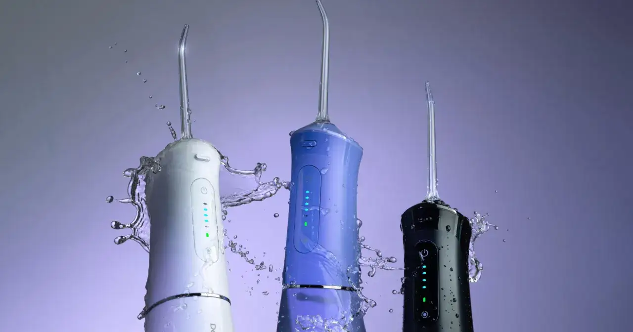 Trzy irygatory w kolorach białym, niebieskim i czarnym w akcji, pokazujące, jak używać irygatora do czyszczenia zęb&oacute;w.