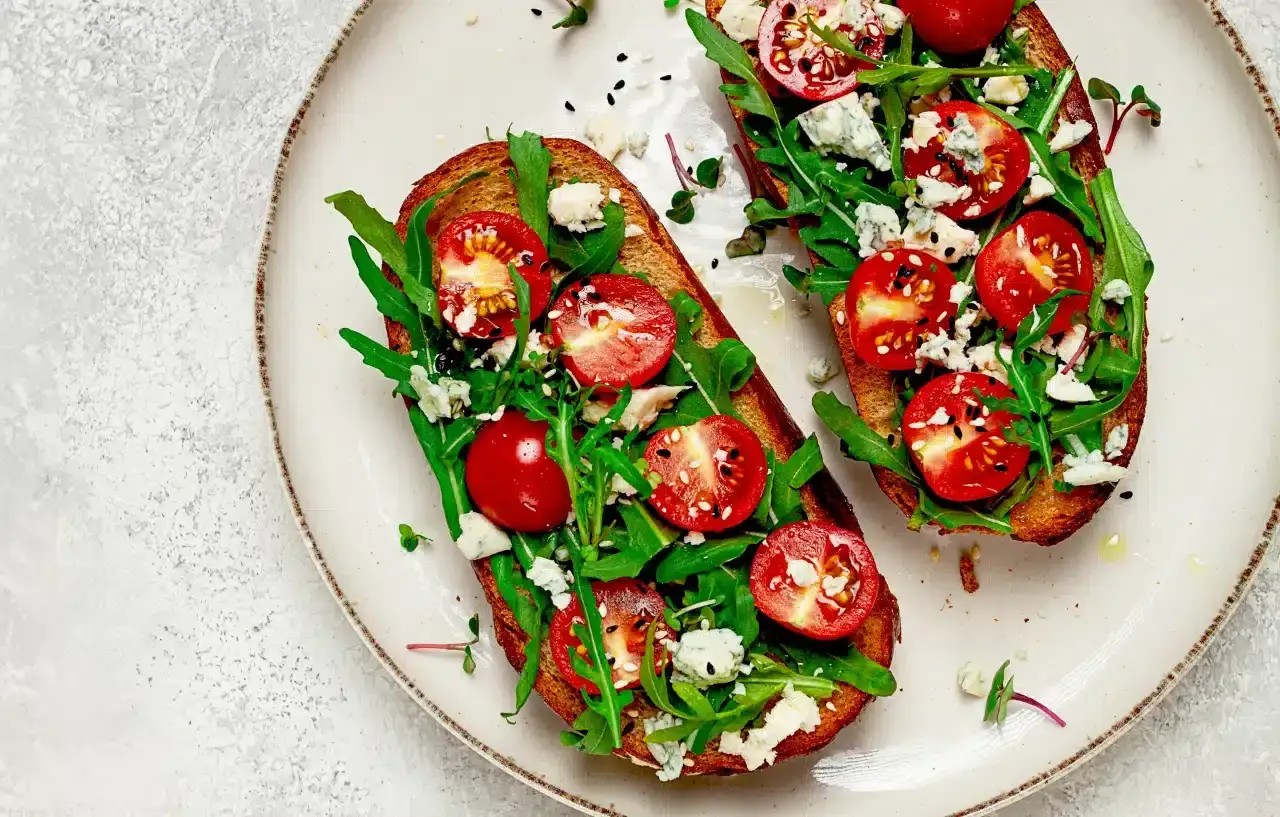 Pyszne tosty z rukolą, pomidorkami i serem pleśniowym – idealne, gdy zastanawiasz się, co zrobić na obiad bezmięsny.
