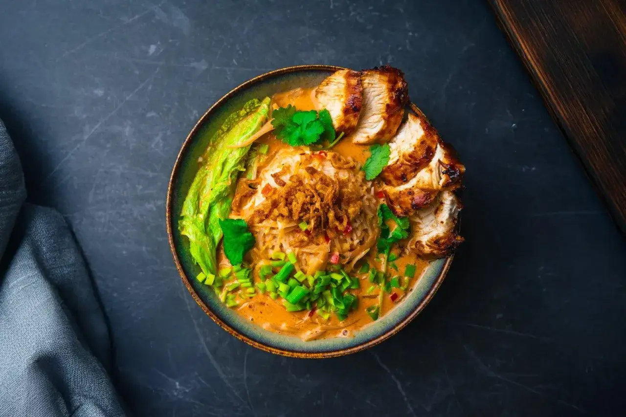 Pyszna zupa z kurczakiem i makaronem ryżowym, idealna na obiad. Aromatyczny bulion, chrupiąca cebulka i świeże zioła.