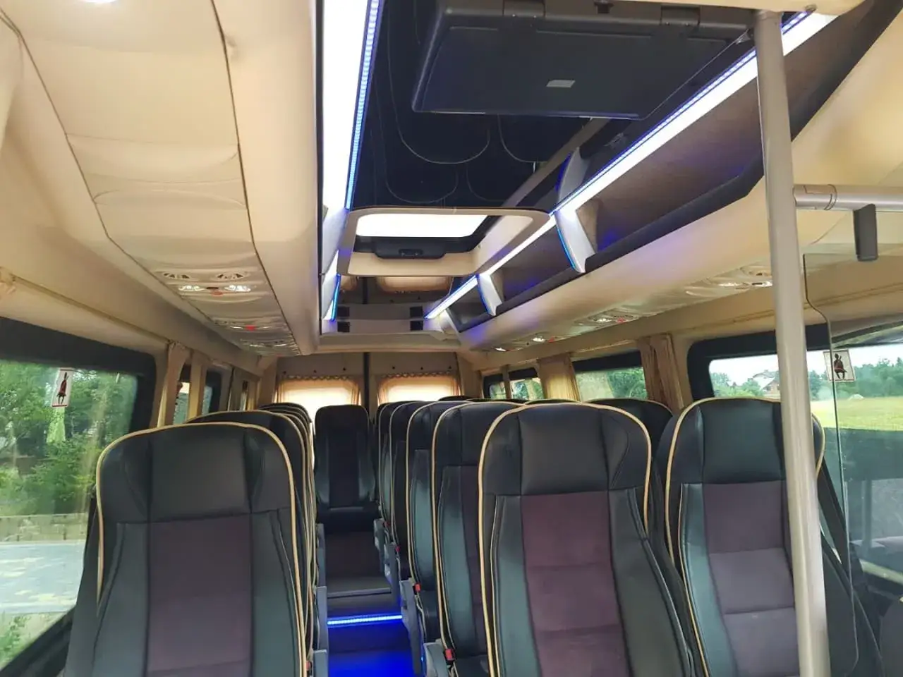 Wnętrze busa z wygodnymi siedzeniami. Nietypowa lokalizacja dla logistyki gości, jak industrialna szklarnia, może być zaskakująca.