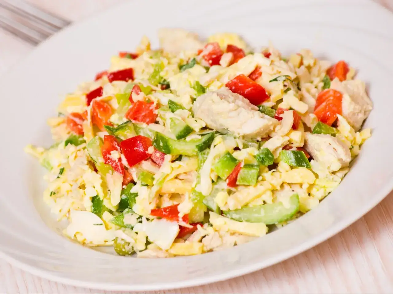 Kolorowa sałatka z kurczakiem, jajkiem, papryką i ogórkiem. Świetny pomysł na to, co można ugotować na szybki obiad.