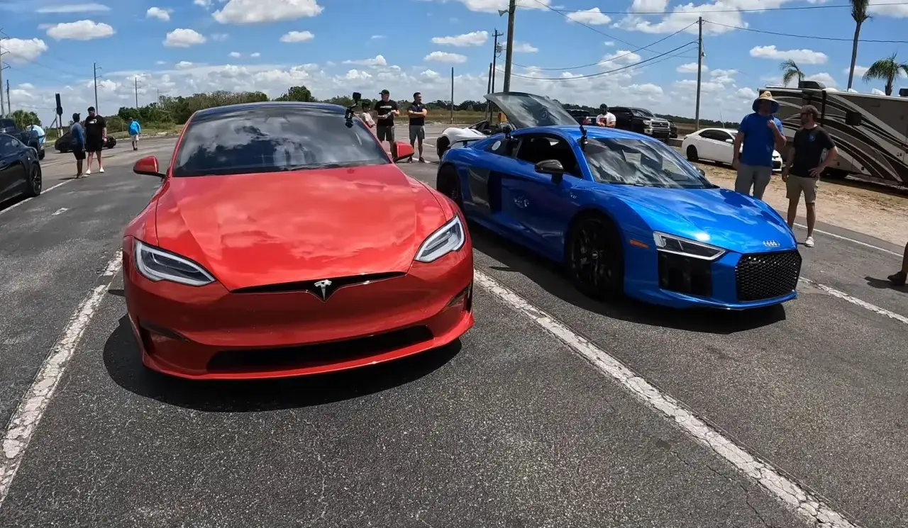 Czerwony Tesla Model S obok niebieskiego Audi R8. Ciekawe, ile koni ma ten Tesla Model S.
