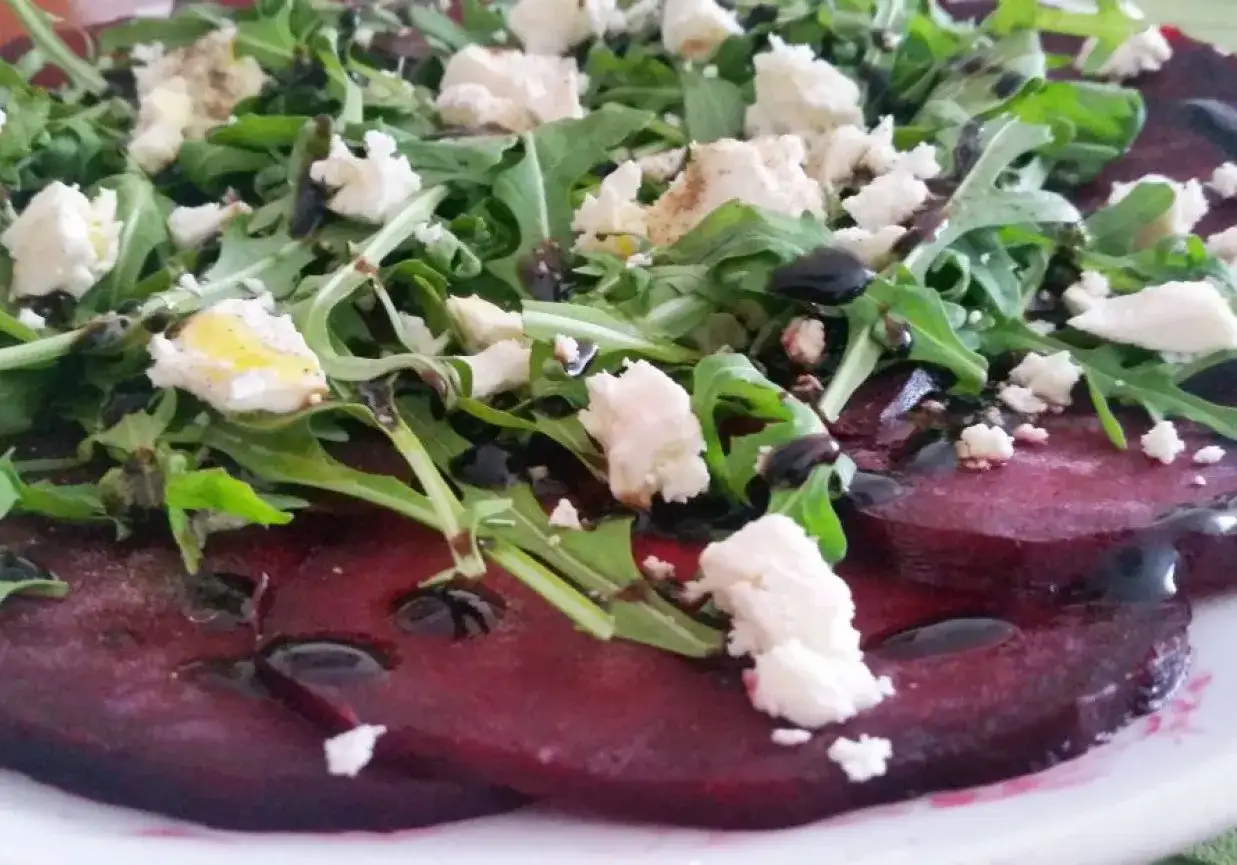 Pyszne carpaccio z buraka z rukolą i fetą, polane balsamicznym sosem.