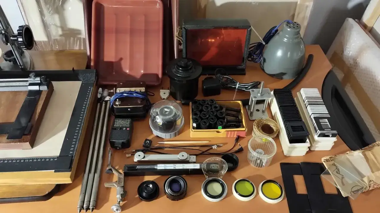 Sprzęt do ciemni fotograficznej: powiększalnik, kuwety, filtry, klisze, lampa.