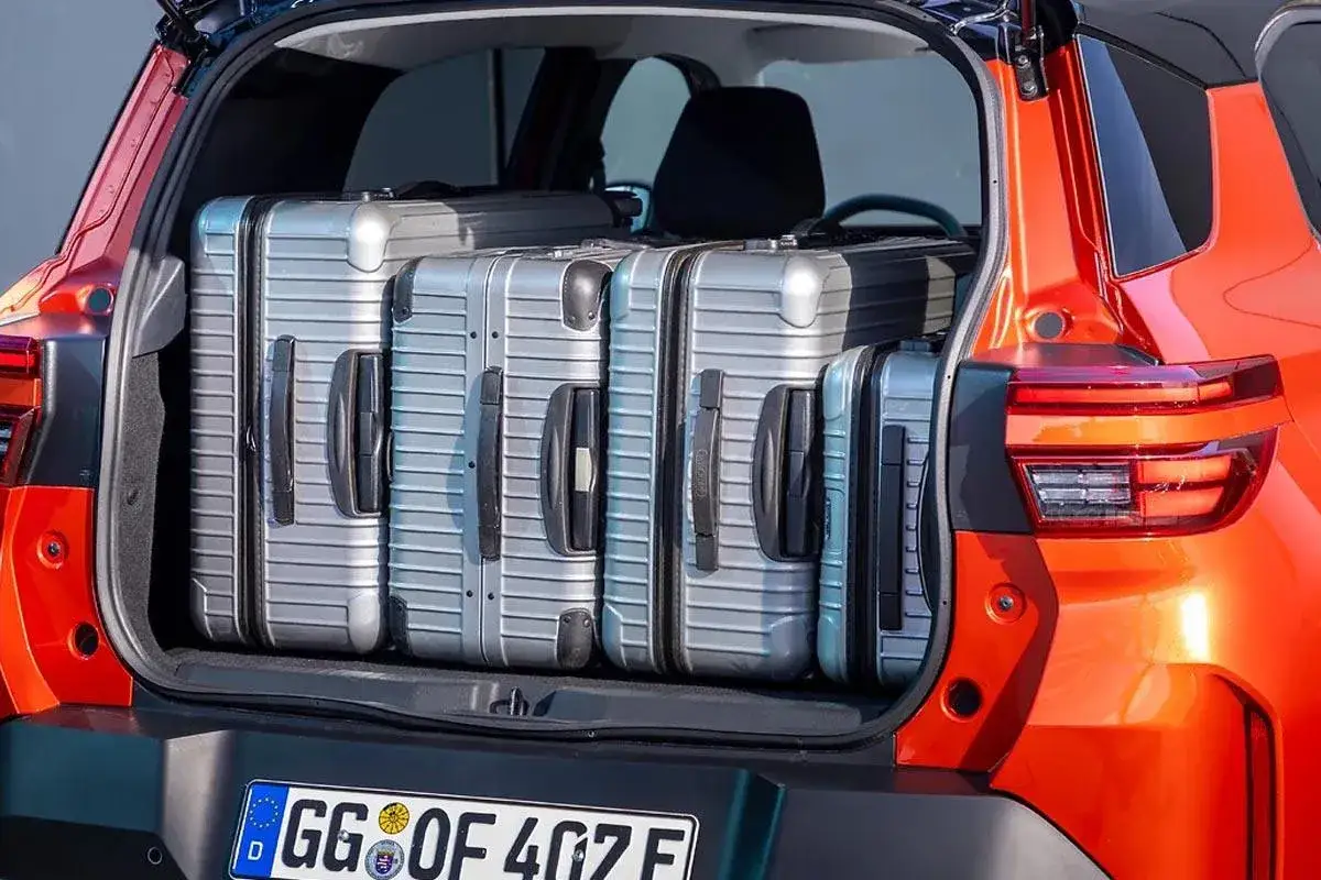 Bagażnik pomarańczowego Opla wypełniony walizkami. Czy to najlepszy Opel na podróż?