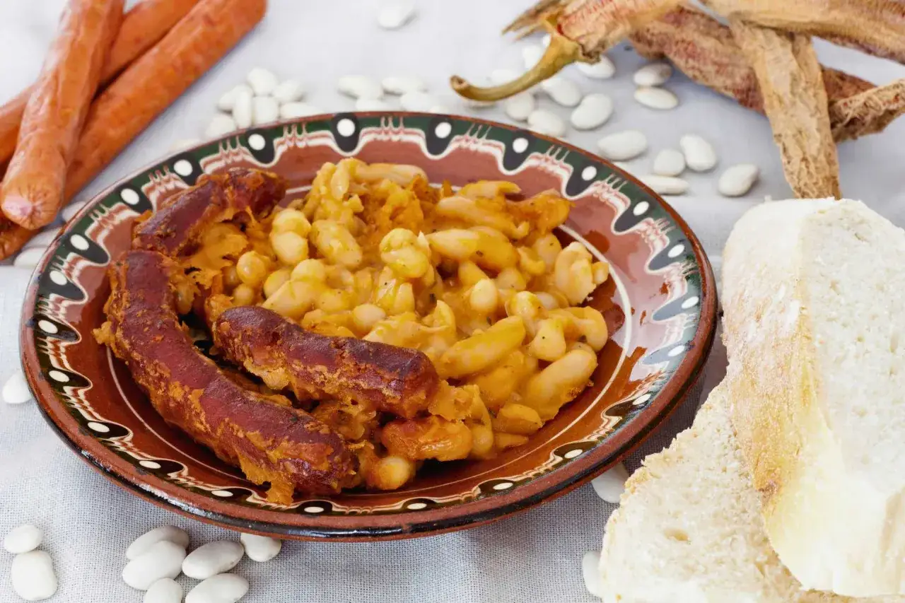 Tavce gravce z kiełbasą, fasolka po bretońsku, chleb i suszone papryczki.