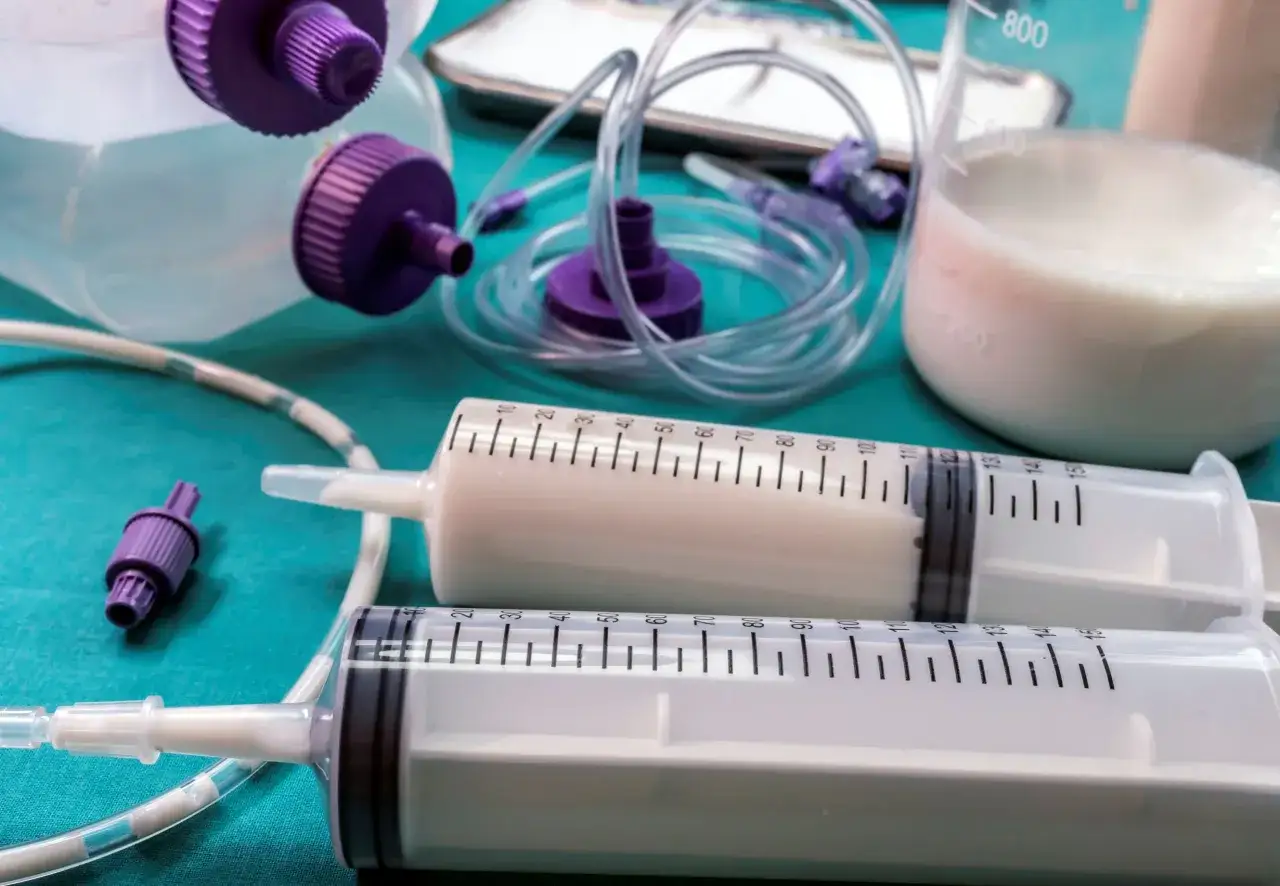 Opiekun medyczny karmiący pacjenta przez sondę