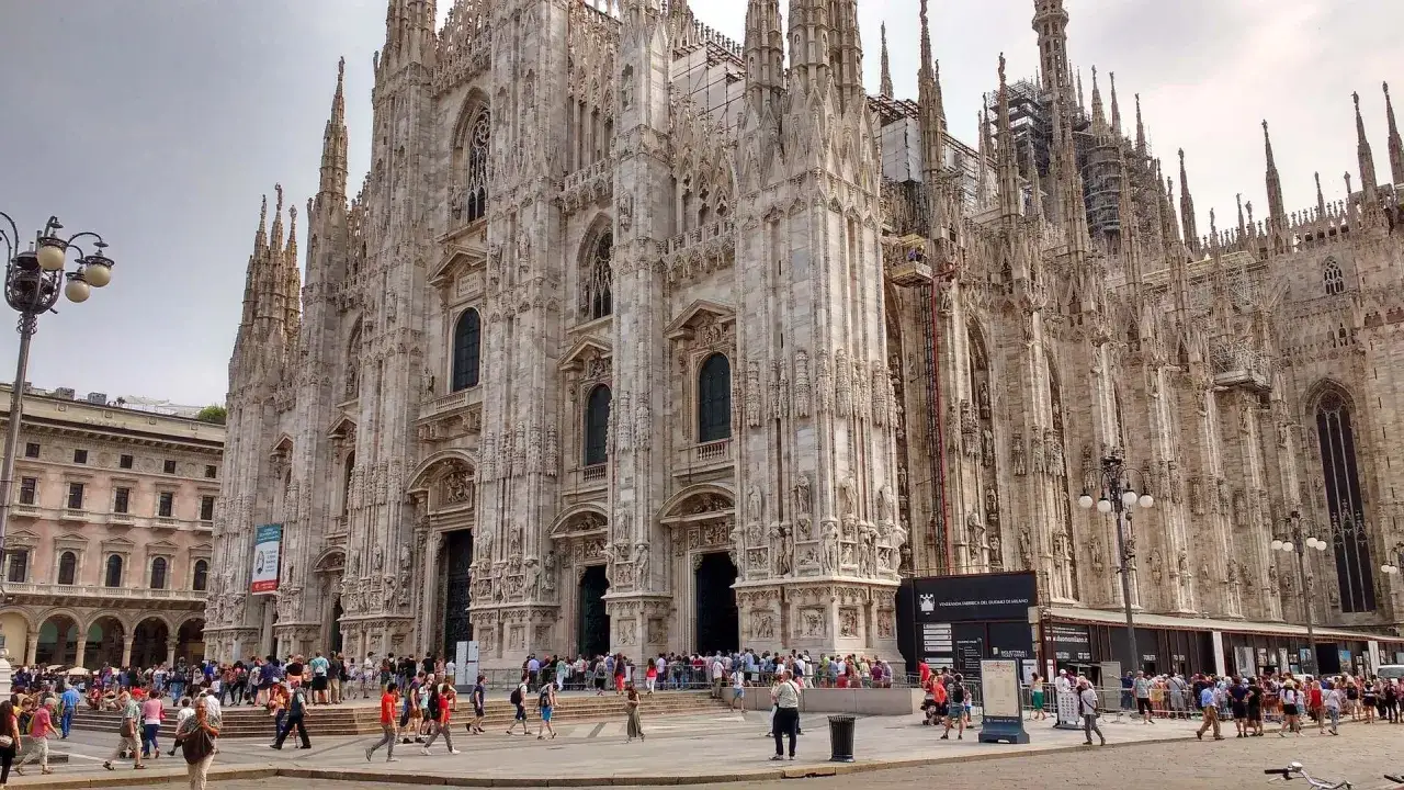 Tłum ludzi przed Katedrą w Mediolanie. Wspaniała architektura gotycka, idealne miejsce na lot do Mediolanu.