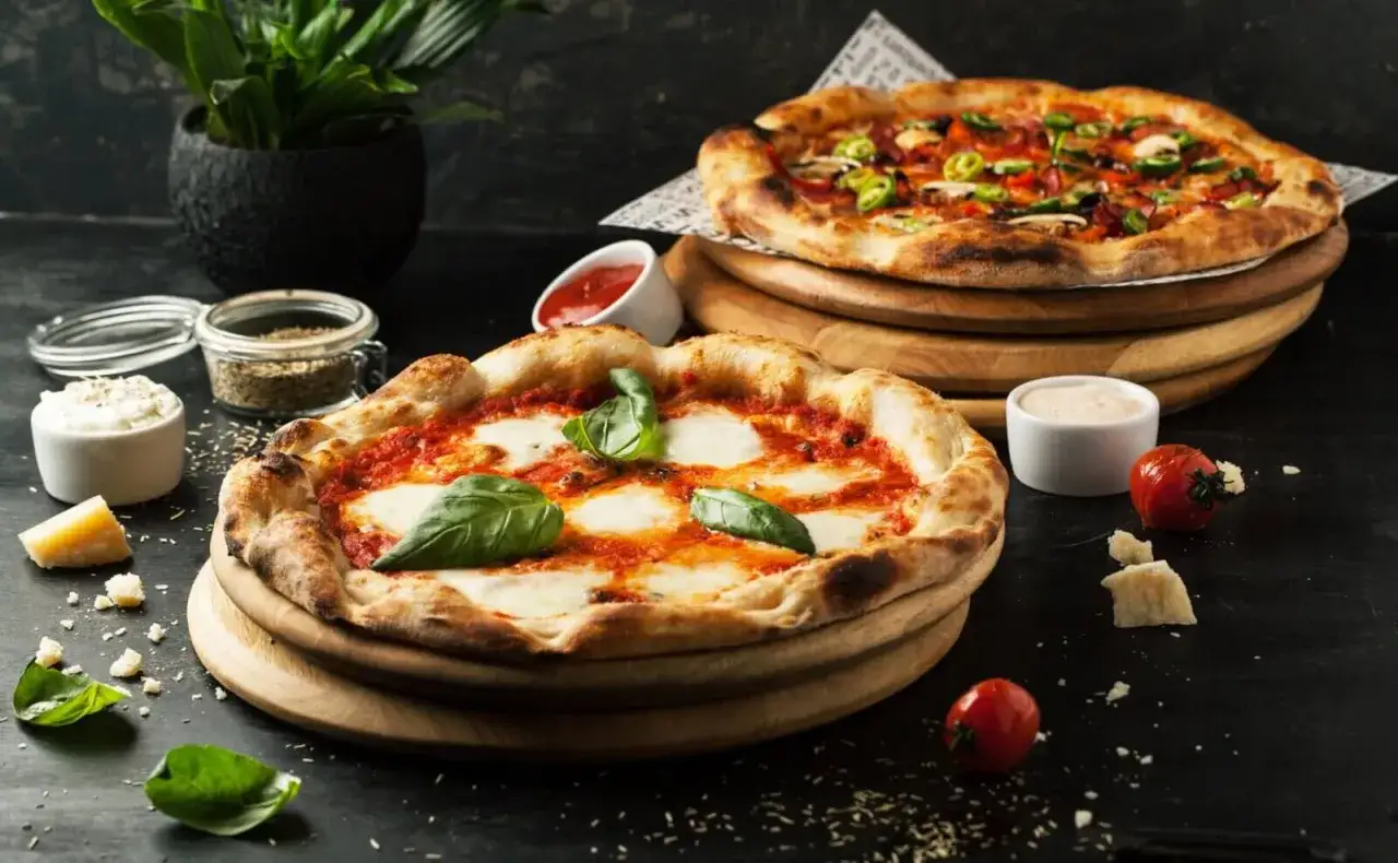 Dwie pyszne pizze, idealne na dzień pizzy. Jedna klasyczna margherita, druga z dodatkami.