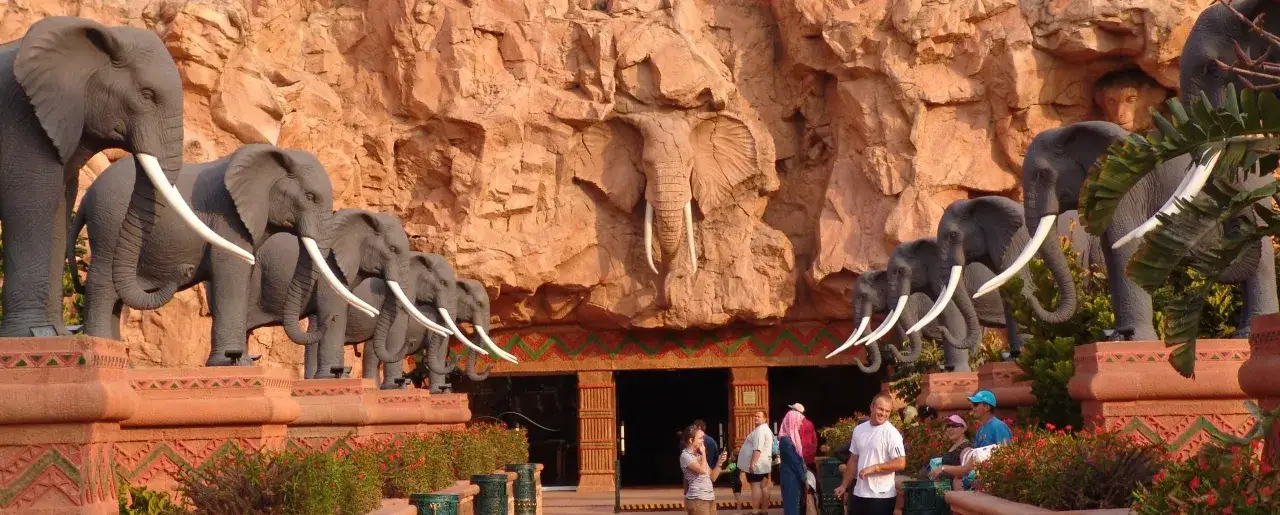 Rząd słoni-rzeźb wita gości w Sun City, RPA. W tle skalna ściana z płaskorzeźbą słonia.