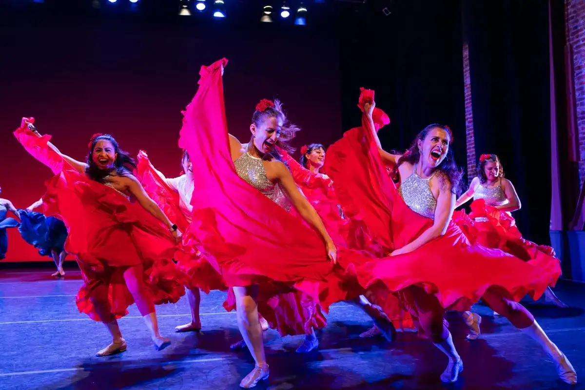 Tancerki w czerwonych sukniach wirują na scenie, prezentując jedne z najpopularniejszych tańc&oacute;w świata.