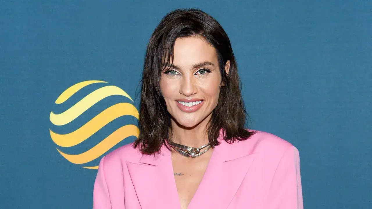 Uśmiechnięta prowadząca Ninja Warrior w r&oacute;żowej marynarce, z charakterystycznym naszyjnikiem.