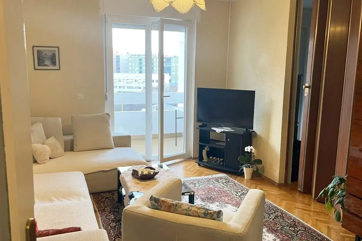 Salon z kanapą, fotelem i TV. Idealne miejsce, by sprawdzić apartament w Chorwacji.