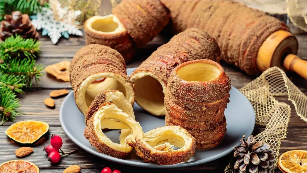 Kürtőskalács, czyli tradycyjne dania węgierskie, na talerzu z dekoracjami świątecznymi.