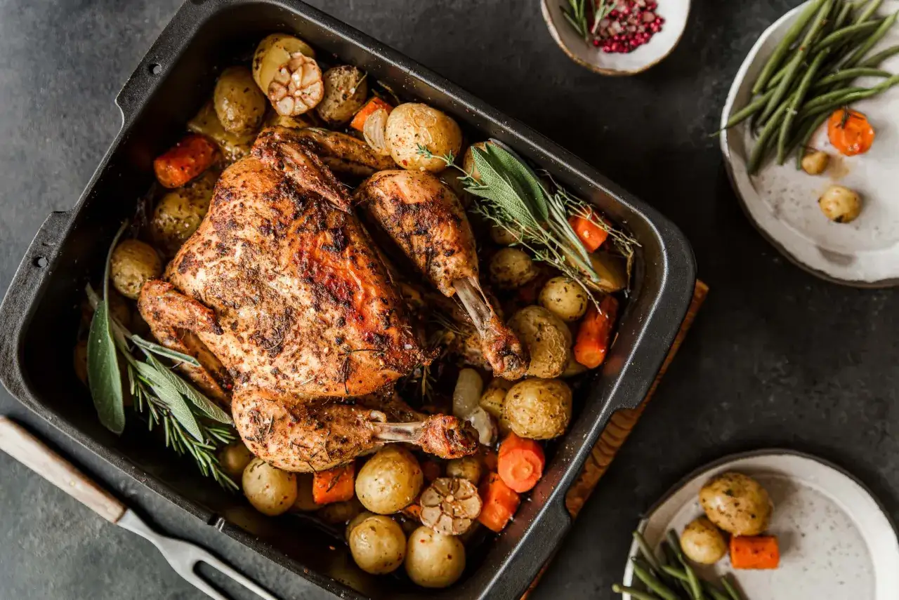 Złocisty kurczak pieczony z ziemniakami, marchewką i ziołami. Idealny sposób, jak przyprawić kurczaka na obiad.