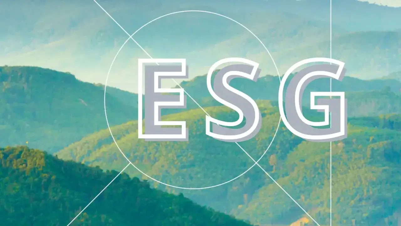 Litery ESG na tle zielonych wzgórz. Dowiedz się, czym jest raport ESG i jak wpływa na przyszłość.