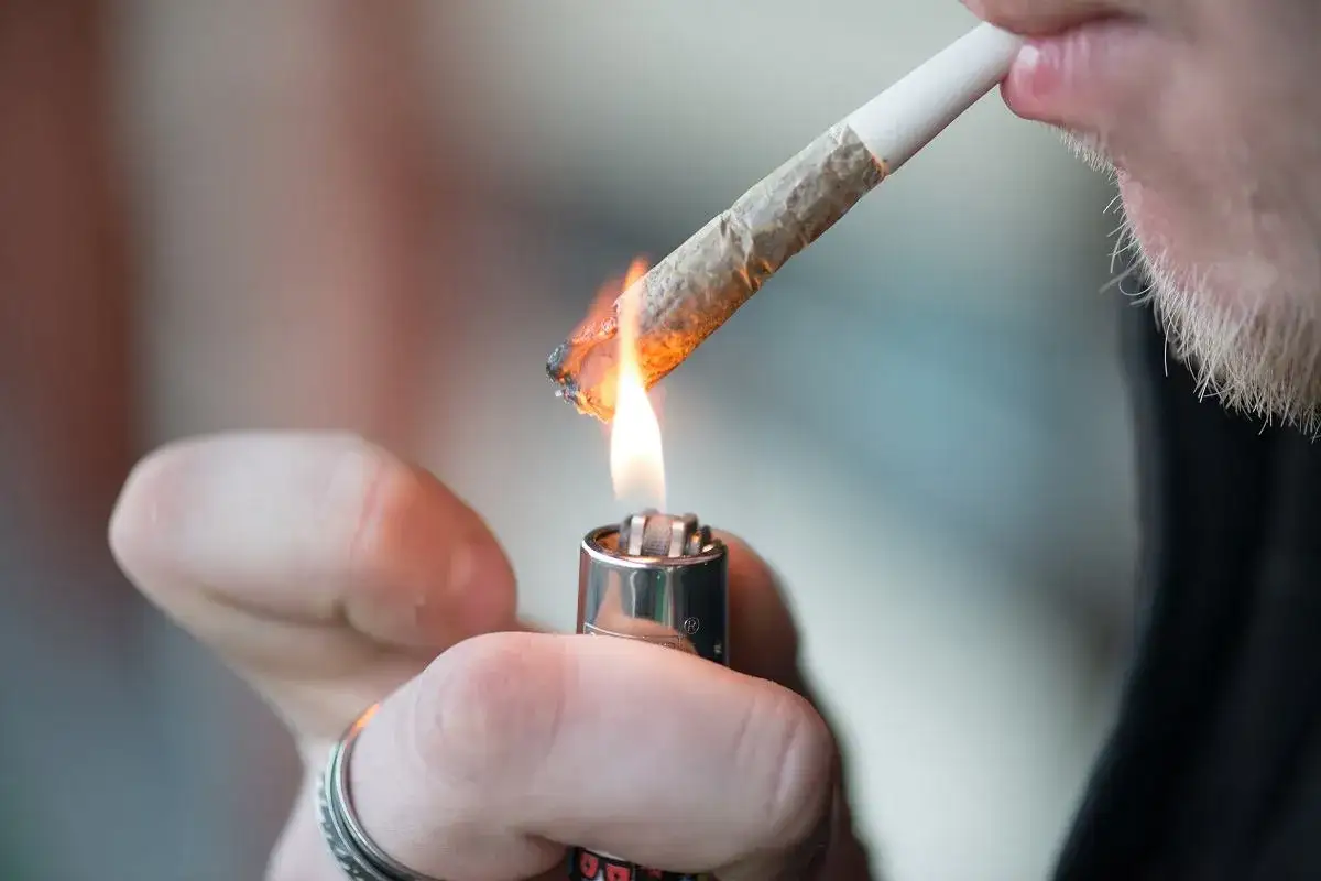 Zbliżenie na zapalanie jointa zapalniczką. Czy palenie marihuany sennik ma znaczenie?