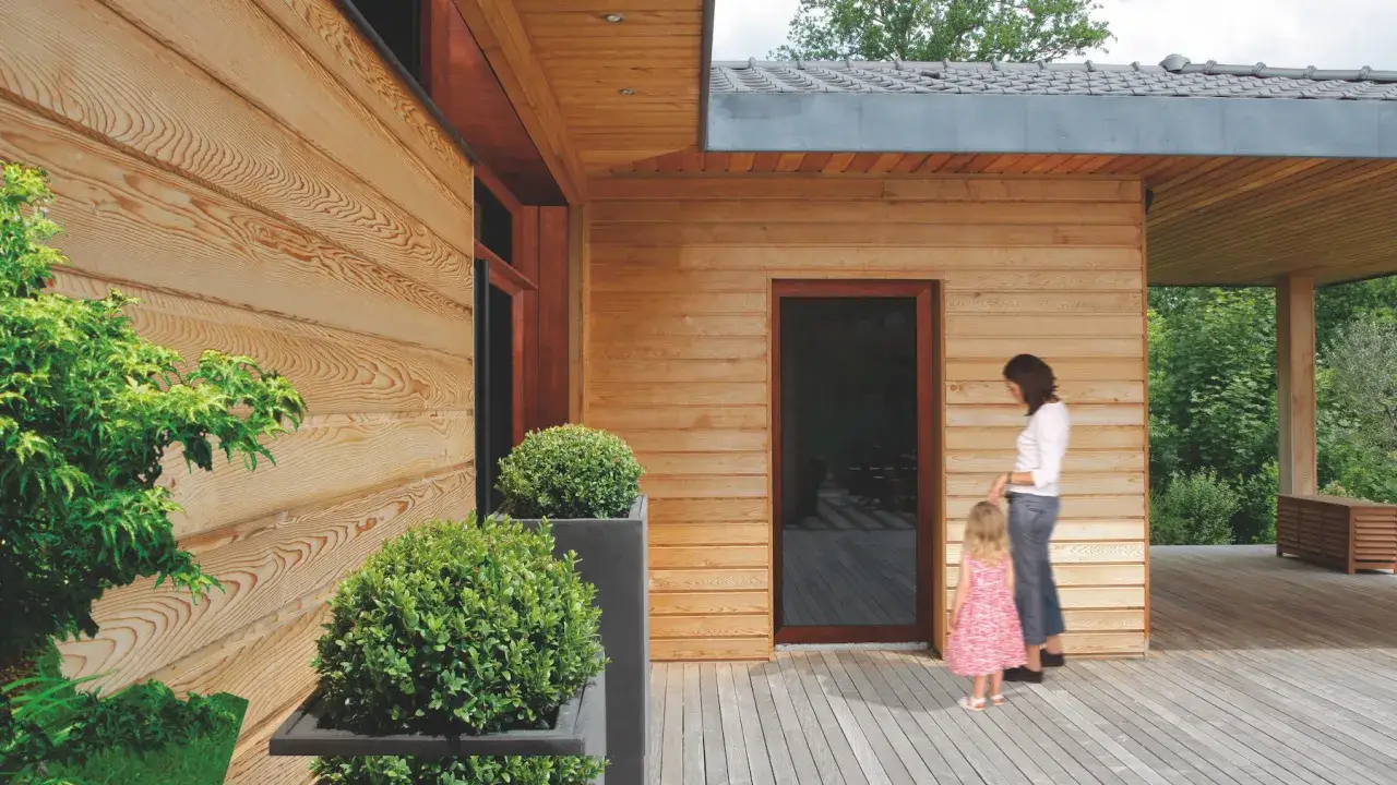 Piękny drewniany dom z tarasem. Wewnątrz pomieszczeń użyto impregnatu do drewna, który podkreśla jego naturalne piękno.