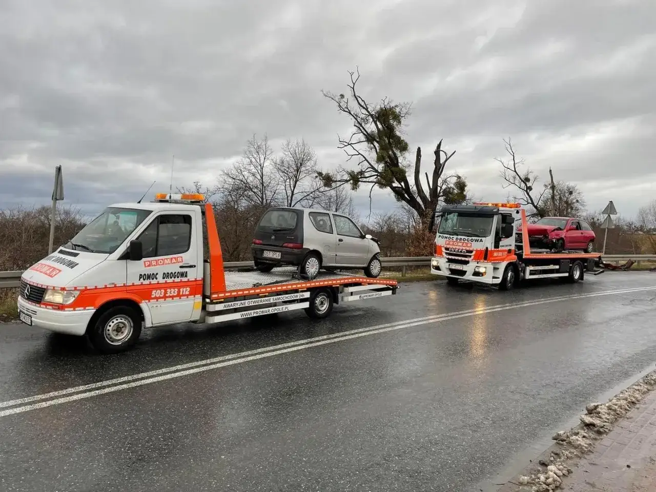 Pomoc drogowa PROMAR oferuje assistance bez OC. Dwa lawety odholowują uszkodzone samochody w deszczowy dzień.