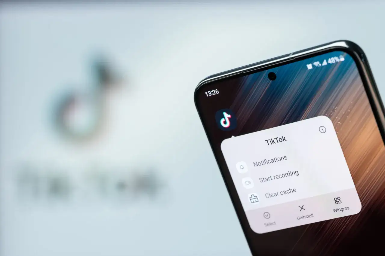 Na ekranie telefonu widać menu aplikacji TikTok z opcją 