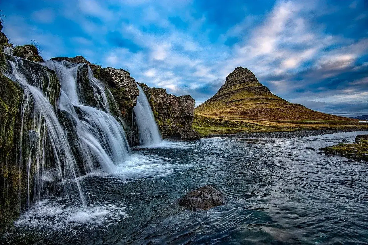 Wodospad Kirkjufellsfoss i charakterystyczna góra Kirkjufell. Idealne miejsce, by zastanowić się, kiedy lecieć na Islandię.