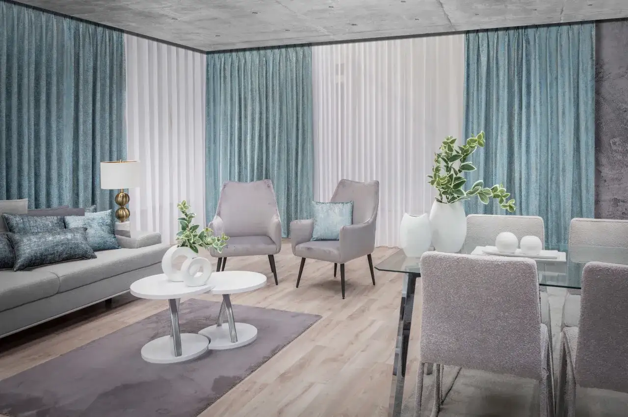 Eleganckie firany w salonie tworzą przytulną atmosferę. Miękkie zasłony w odcieniach błękitu i bieli pięknie komponują się z nowoczesnym wystrojem.