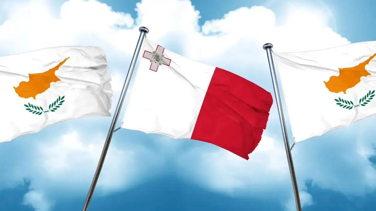 Flagi Cypru i Malty powiewają na tle błękitnego nieba. Który kraj wybierzesz na wakacje: Cypr czy Malta?