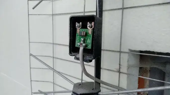 Wnętrze puszki anteny siatkowej, podłączenie kabla do symetryzatora, płytka wzmacniacza antenowego