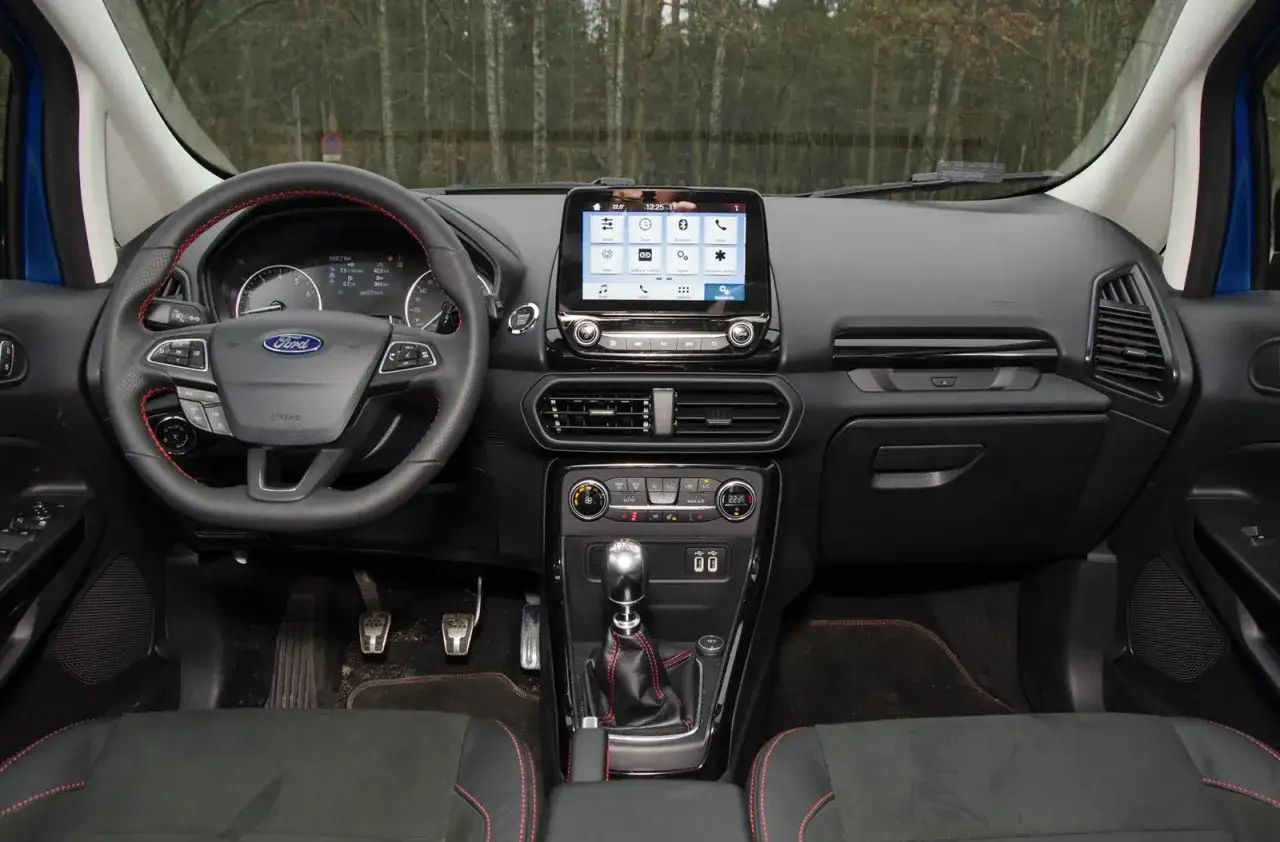 Wnętrze Ford EcoSport z ekranem dotykowym, kierownicą i manualną skrzynią biegów.