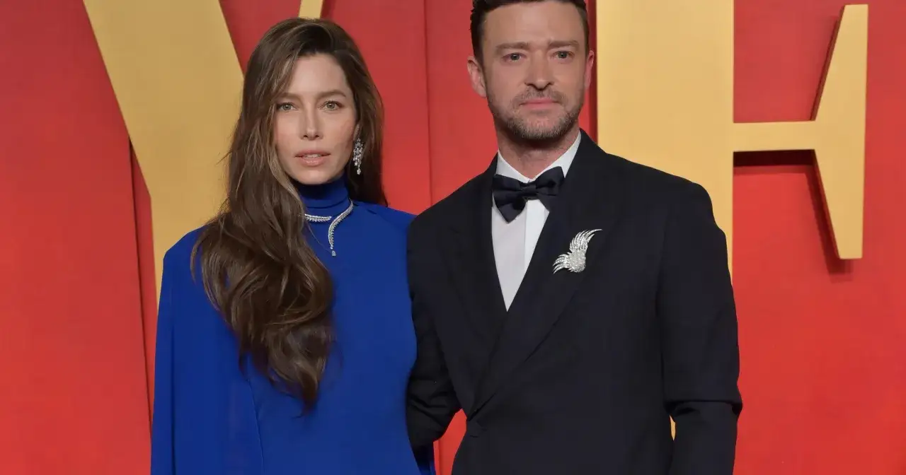 Jessica Biel i Justin Timberlake na czerwonym dywanie. Ona w eleganckiej, niebieskiej sukni i biżuterii, on w klasycznym smokingu z ozdobną broszką.