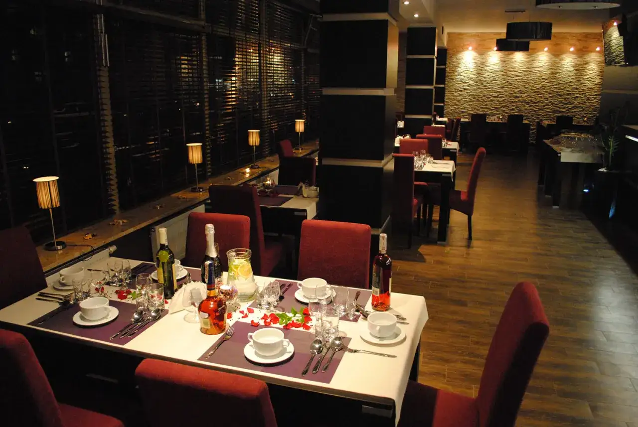 Elegancka restauracja z czerwonymi krzesłami i nakrytymi stołami, idealne miejsce, gdzie dobrze zjeść w Chełmie.