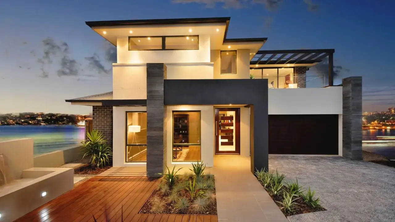 Nowoczesne oświetlenie elewacji podkreśla architekturę domu z widokiem na wodę i miasto.