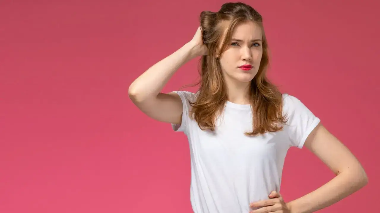 Kobieta zamyślona, poprawia włosy. Czy to gest stresu, czy może psychologia poprawiania włos&oacute;w w działaniu?