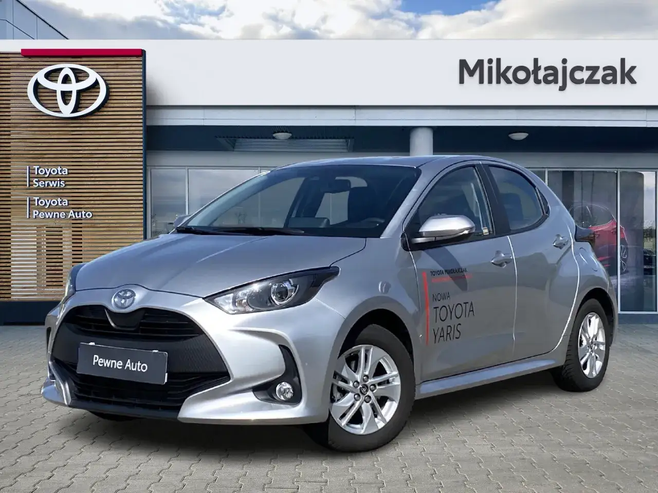 Srebrna Toyota Yaris przed salonem Mikolajczak. Sprawdź, ile kosztuje Toyota Yaris i znajdź sw&oacute;j wymarzony samoch&oacute;d.