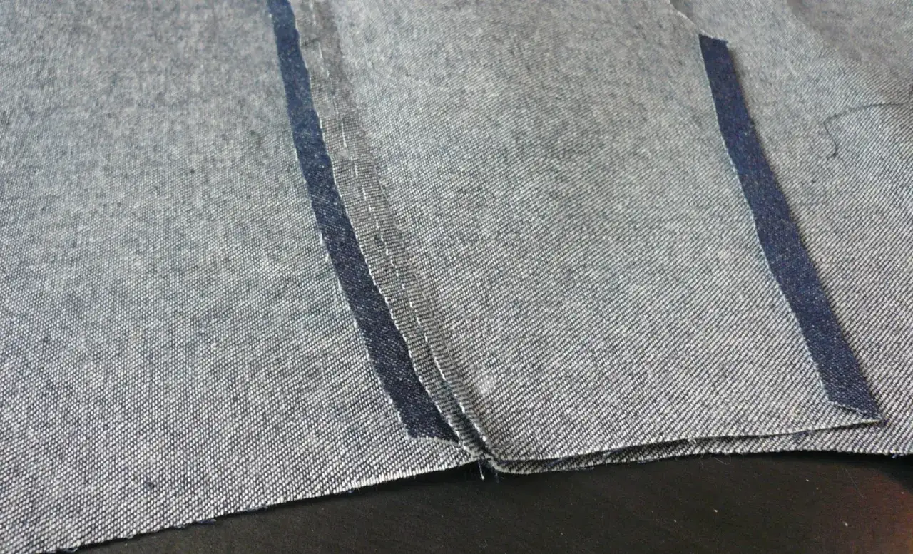 Zbliżenie na dekatyzowany jeans z widocznymi szwami i przetarciami.