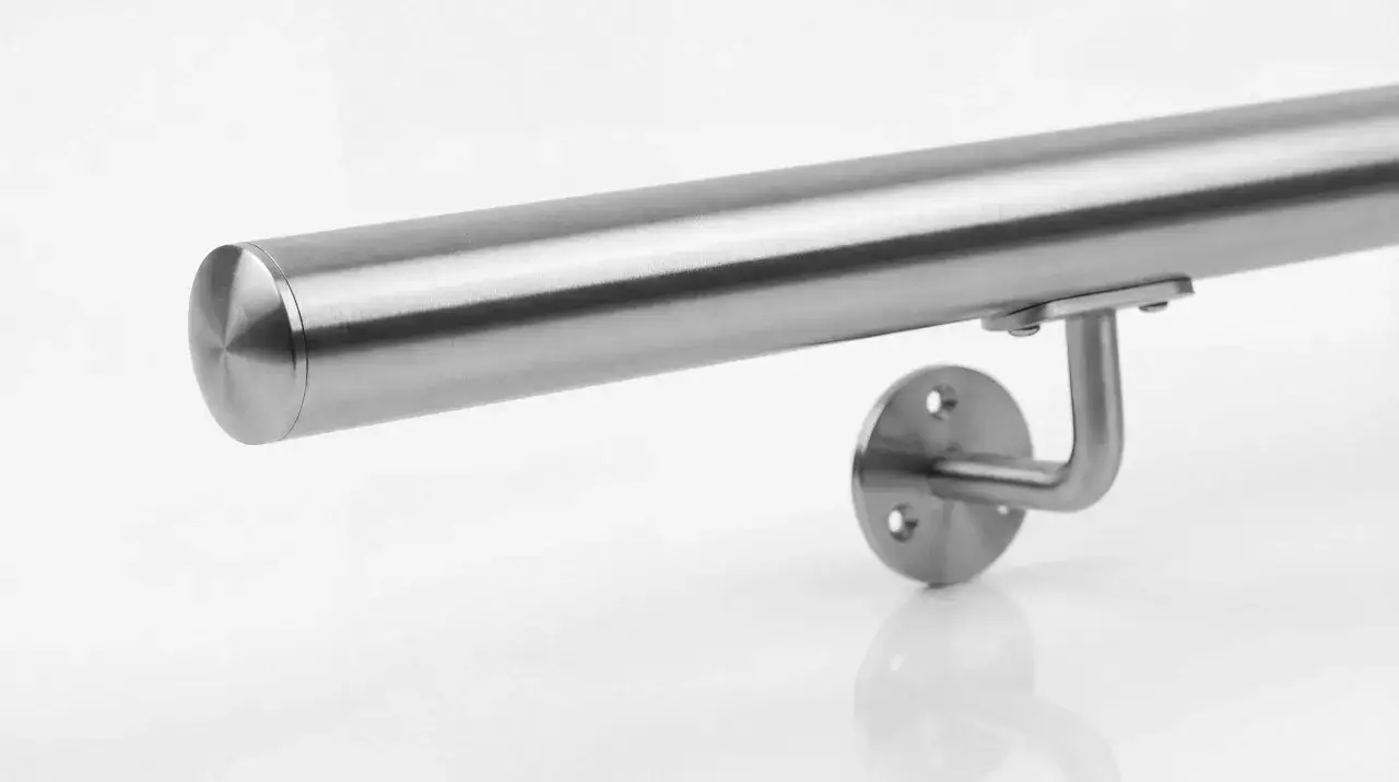 Metalowa poręcz schodowa, przypominająca kształtem gęsią szyję, zamontowana na białym tle.