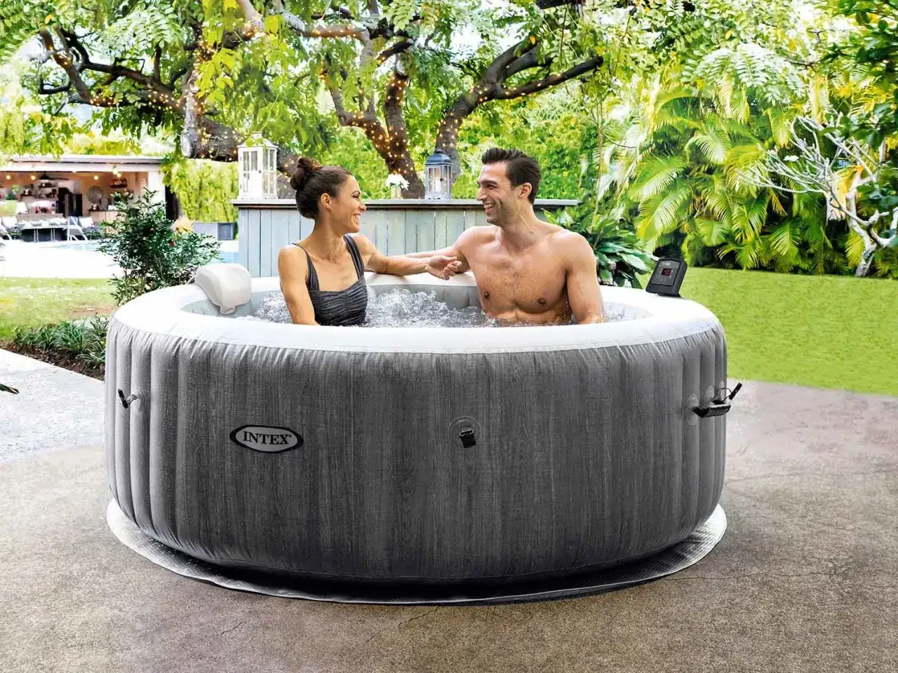 Para relaksu w ogrodzie: para cieszy się kąpielą w dmuchanych basenach spa ogrodowych, otoczona zielenią i światłami.