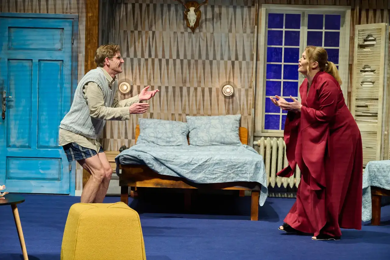 Aktorzy na scenie, w scenografii przypominającej sypialnię, tworzą emocjonującą scenę. To może być najlepszy teatr w Warszawie.